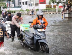 *Aksi Humanis Polisi di Jakbar, Bantu Warga Melintas di Tengah Genangan Banjir